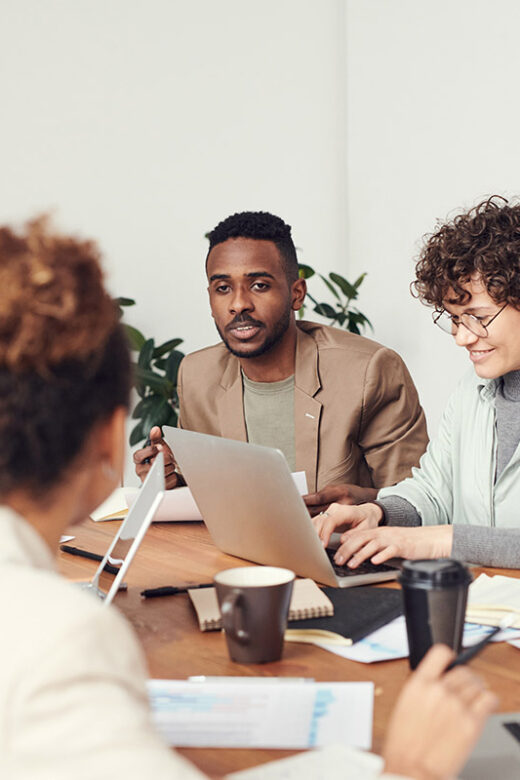 group of young professionals having a meeting over laptops and coffee